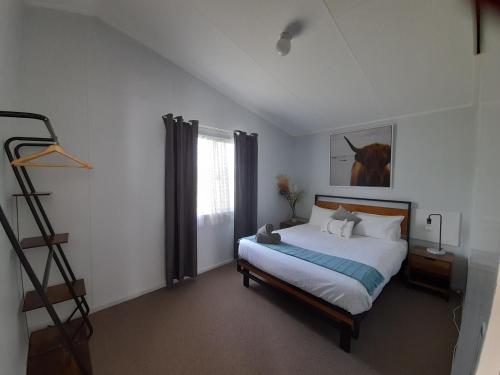 1 dormitorio con 1 cama con una foto de caballo en la pared en Kalgan River Chalets and Caravan Park en Kalgan