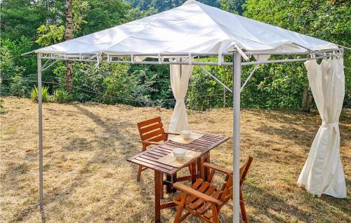 stół i krzesła pod białym baldachimem w obiekcie Nice Apartment In Santo Stefano Daveto w mieście Santo Stefano dʼAveto
