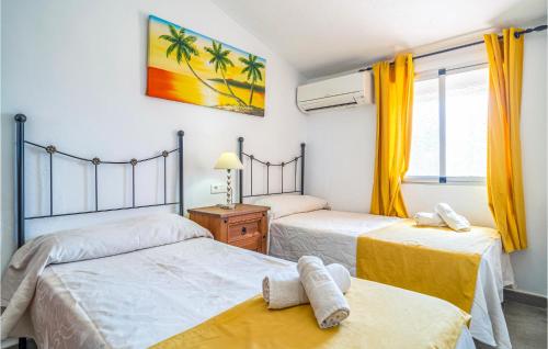 een slaapkamer met 2 bedden, gele gordijnen en een raam bij Lovely Home In Nerja With House A Panoramic View in Nerja