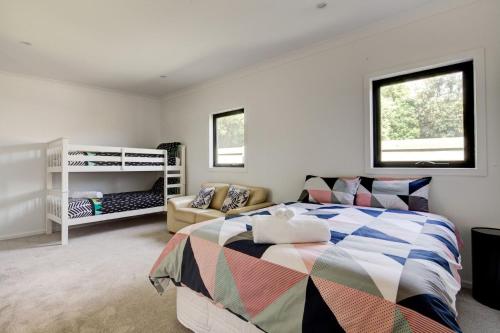 ein Schlafzimmer mit einem Bett und einem Sofa in der Unterkunft East Tempy House and Bungalow in Port Fairy
