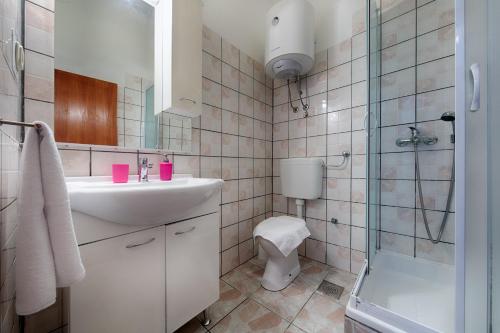 ein Bad mit einem Waschbecken, einem WC und einer Dusche in der Unterkunft Apartments by the sea Vis - 2453 in Vis