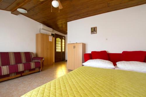 a bedroom with a red bed and a couch at Apartment Milna 2461c in Rukavac