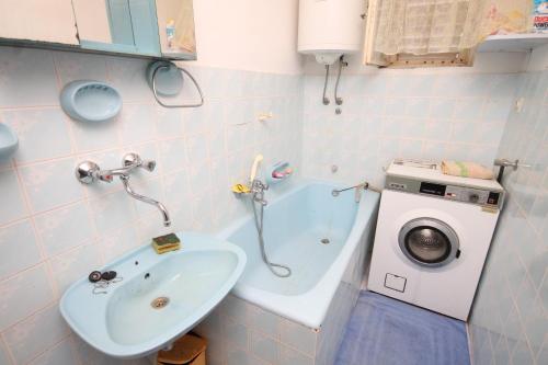 La salle de bains est pourvue d'un lavabo et d'un lave-linge. dans l'établissement Apartments with a parking space Podselje, Vis - 2462, à Vis