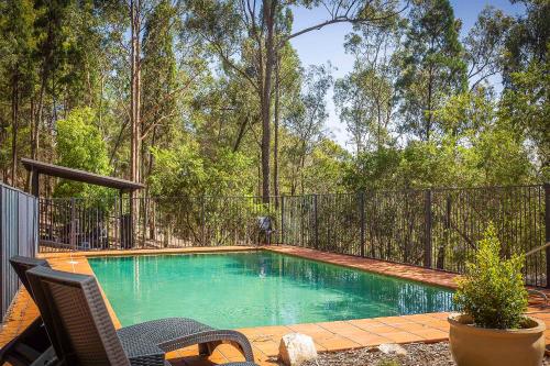 a swimming pool in a yard with a fence at Villa Andante in Pokolbin
