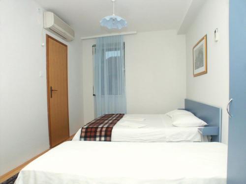 a bedroom with two beds and a window at Studio Komiza 2429e in Komiža