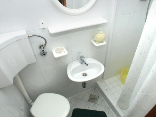 a small bathroom with a toilet and a sink at Studio Komiza 2429e in Komiža