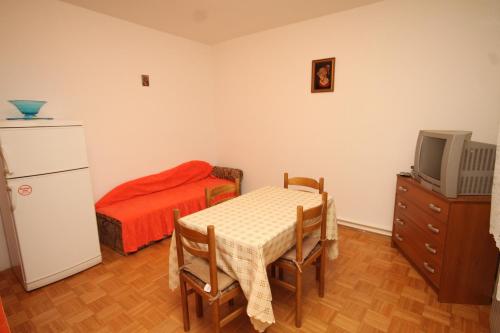 a room with a table and a bed and a television at Apartments and rooms with parking space Mali Losinj (Losinj) - 2486 in Mali Lošinj