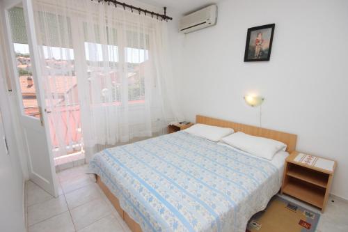 a white bedroom with a bed and a window at Apartments and rooms with parking space Mali Losinj (Losinj) - 2486 in Mali Lošinj