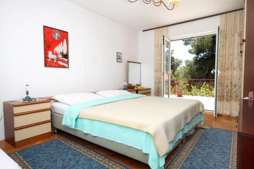 a bedroom with a bed and a large window at Apartments by the sea Mali Losinj (Losinj) - 2493 in Mali Lošinj
