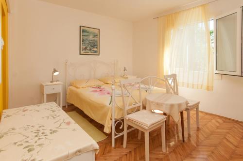 sypialnia z łóżkiem, stołem i krzesłami w obiekcie Apartments and rooms with parking space Mali Losinj (Losinj) - 2497 w miejscowości Mali Lošinj