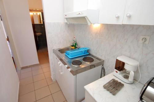 a small kitchen with a sink and a stove at Apartments with a parking space Mali Losinj (Losinj) - 2507 in Mali Lošinj
