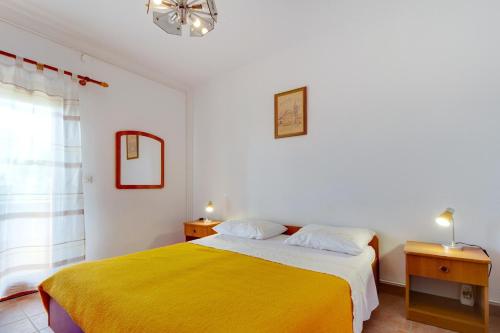 a bedroom with a bed with a yellow blanket at Apartments and rooms with parking space Nerezine, Losinj - 2506 in Nerezine