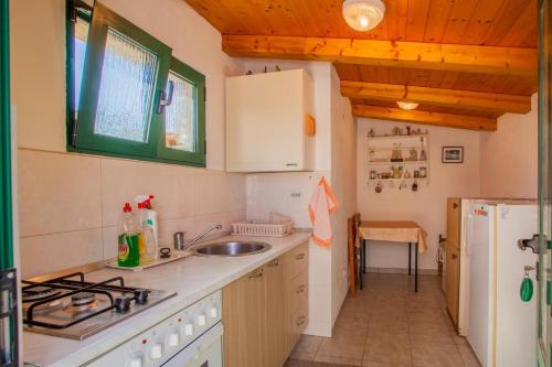 a kitchen with a sink and a refrigerator at Rooms with a parking space Cres - 2512 in Cres