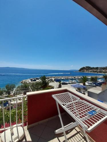 a balcony with a table and chairs and the ocean at Apartments and rooms by the sea Podgora, Makarska - 2616 in Podgora