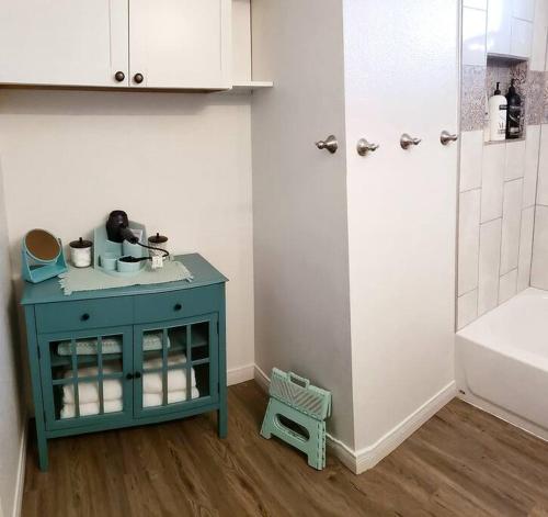 a bathroom with a blue cabinet and a shower at RnR Beach House: 1 mi to Ocean,Pier, Harbor, Beach in Oceanside