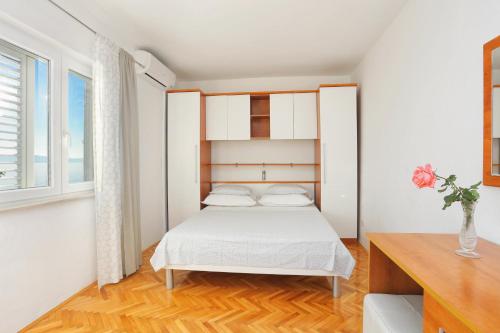 - une petite chambre avec un lit et une fenêtre dans l'établissement Apartments by the sea Podgora, Makarska - 2657, à Podgora
