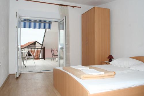 a bedroom with a bed and a view of a balcony at Apartments by the sea Podaca, Makarska - 2612 in Podaca