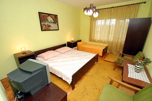 una camera con letto e TV di Apartments and rooms by the sea Zaostrog, Makarska - 2661 a Zaostrog