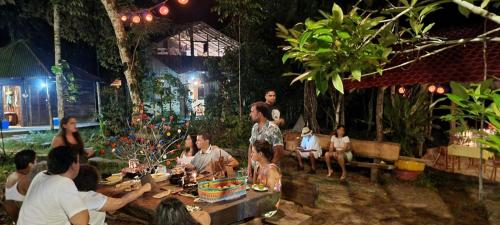 a group of people sitting around a table in a garden at Refúgio Samauma in Manaus