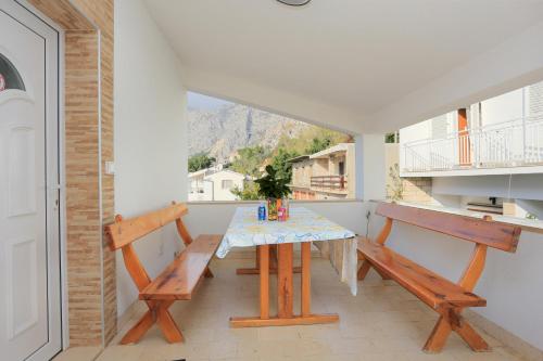 jadalnia ze stołem i 2 ławkami w obiekcie Apartments by the sea Drasnice, Makarska - 2644 w mieście Drašnice