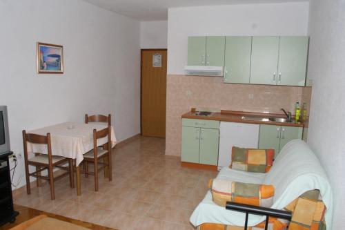 een keuken en een eetkamer met een tafel en een keuken bij Apartments by the sea Igrane, Makarska - 2679 in Igrane