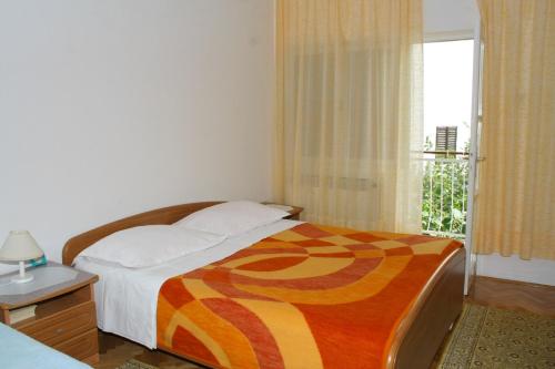 a bedroom with a bed and a window at Apartments and rooms by the sea Zaostrog, Makarska - 2662 in Zaostrog