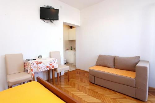 a living room with a couch and a table at Studio Promajna 2605b in Promajna