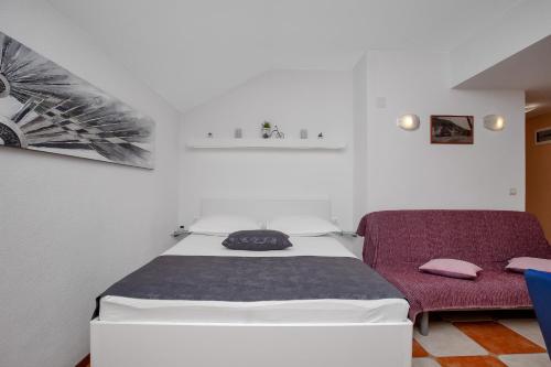 a small bedroom with a bed and a chair at Apartments by the sea Drasnice, Makarska - 2581 in Drasnice