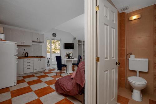 a bathroom with a toilet and a kitchen with a table at Apartments by the sea Drasnice, Makarska - 2581 in Drasnice