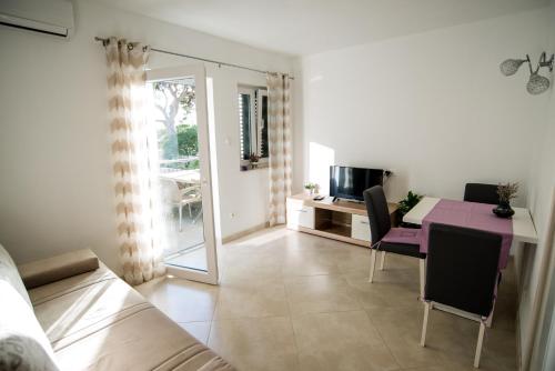 a living room with a purple table and a tv at Apartments by the sea Promajna, Makarska - 2605 in Promajna