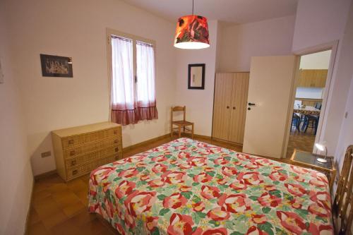 マルチャーナにあるVillino Le Sughereのベッドルーム1室(花柄のベッドカバー付)
