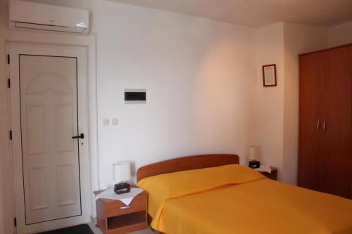 ein Schlafzimmer mit einem Bett mit einer gelben Decke in der Unterkunft Apartments by the sea Zaostrog, Makarska - 2625 in Zaostrog