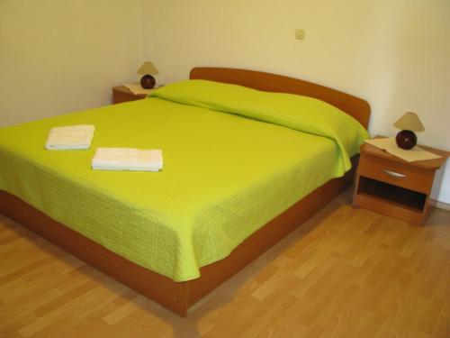 a bedroom with a green bed with two night stands at Apartment Zaostrog 2625a in Zaostrog