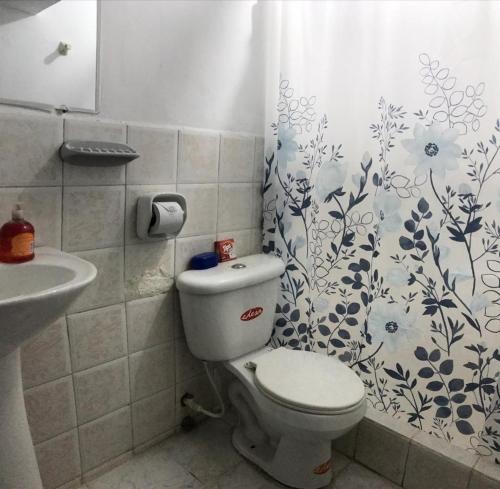 a bathroom with a toilet and a sink and a shower curtain at Acogedor, amplio a 5 min de Las Palmas-Esmeraldas in Esmeraldas