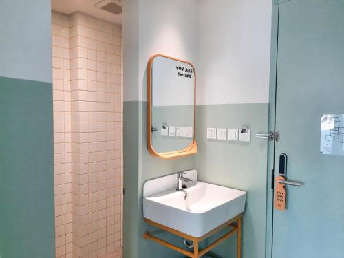 a bathroom with a sink and a mirror at Kotta Hotel Semarang in Semarang