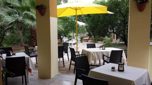 a restaurant with tables and a yellow umbrella at B&B Pittoresco in Specchia
