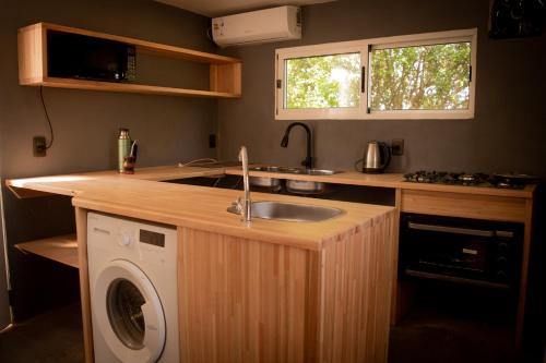 a kitchen with a sink and a washing machine at Villa Pancha del Lunarejo in Sierra de Lunarejo