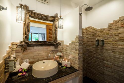 a bathroom with a sink and a mirror at Laksasubha Hua Hin in Hua Hin