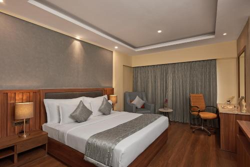 a hotel room with a bed and a desk and chair at Southern Star,Bangalore in Bangalore