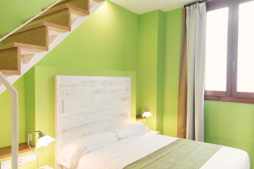 バレンシアにあるアド ホック カルメンの緑の壁と階段のあるベッドルーム