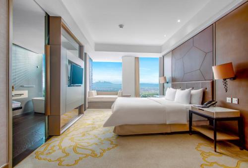 a bedroom with a large bed and a bathroom at InterContinental Bandung Dago Pakar by IHG in Bandung