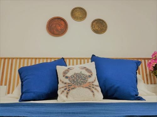 a bed with pillows and clocks on the wall at Spitaki Apartments Potos in Potos