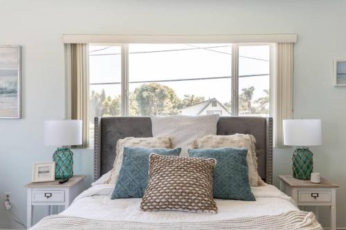 una camera da letto con letto, cuscini e finestra di Coastal Rooftop Retreat a Carpinteria