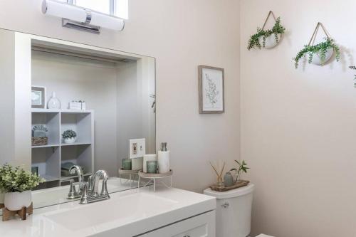 bagno bianco con lavandino e specchio di Coastal Rooftop Retreat a Carpinteria
