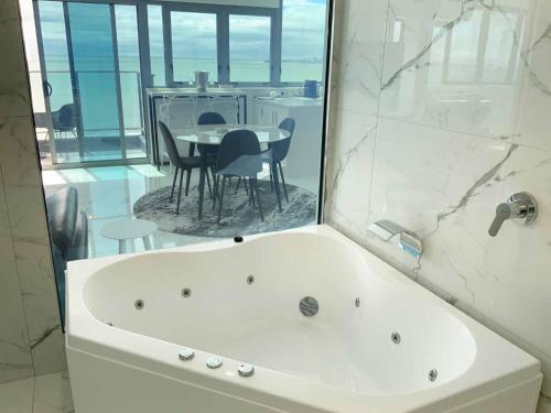 a bathroom with a tub and a table with chairs at Beachfront Towers in Maroochydore