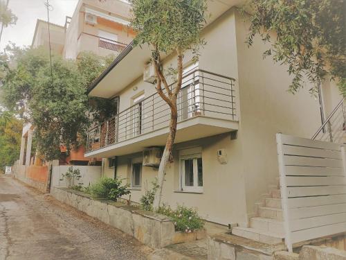 a white building with stairs and a balcony at Spitaki Apartments Potos in Potos