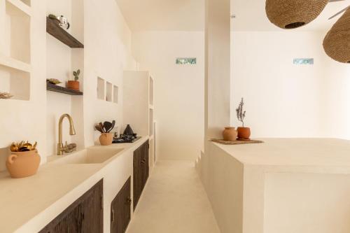 ein Badezimmer mit weißen Waschtischen und einem Waschbecken in der Unterkunft Villa Ores Bali in Canggu