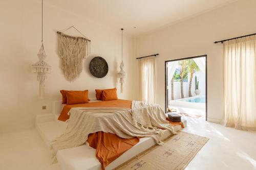 ein Schlafzimmer mit einem Bett mit orangefarbenen Kissen in der Unterkunft Villa Ores Bali in Canggu