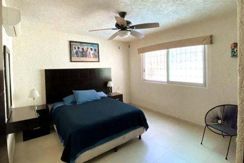 a bedroom with a bed and a ceiling fan at Hermoso departamento con alberca in Acapulco