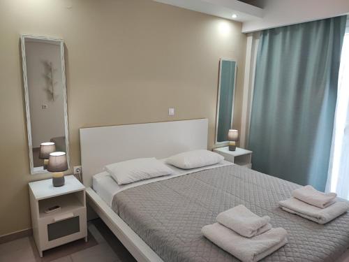 a bedroom with a large bed with two towels on it at Meraki Skopelos in Skopelos Town